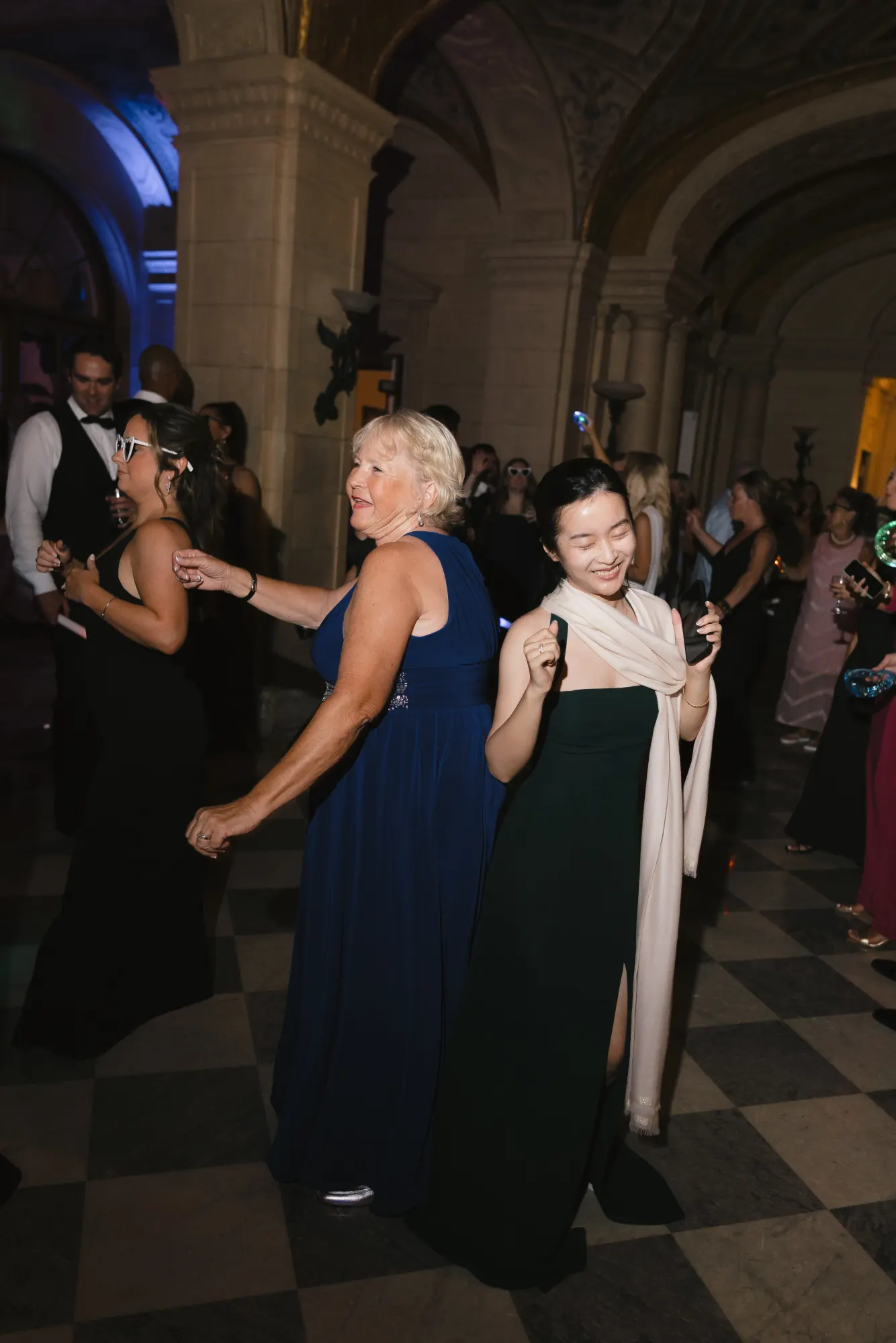 Glow wands wave through the marble hall