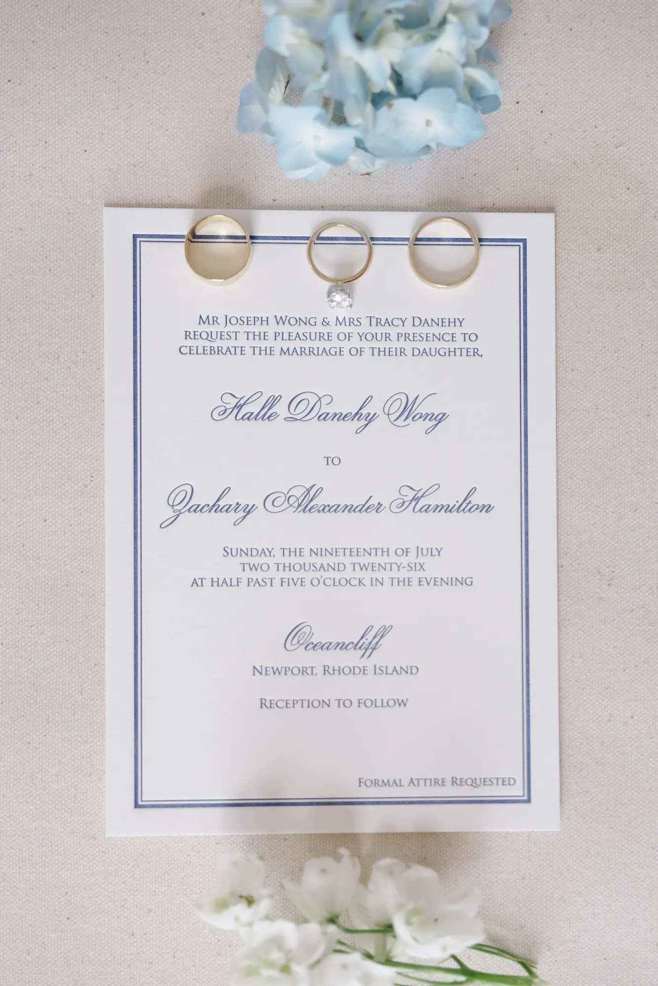 Wedding invitation with the three rings and blue hydrangea styled above it