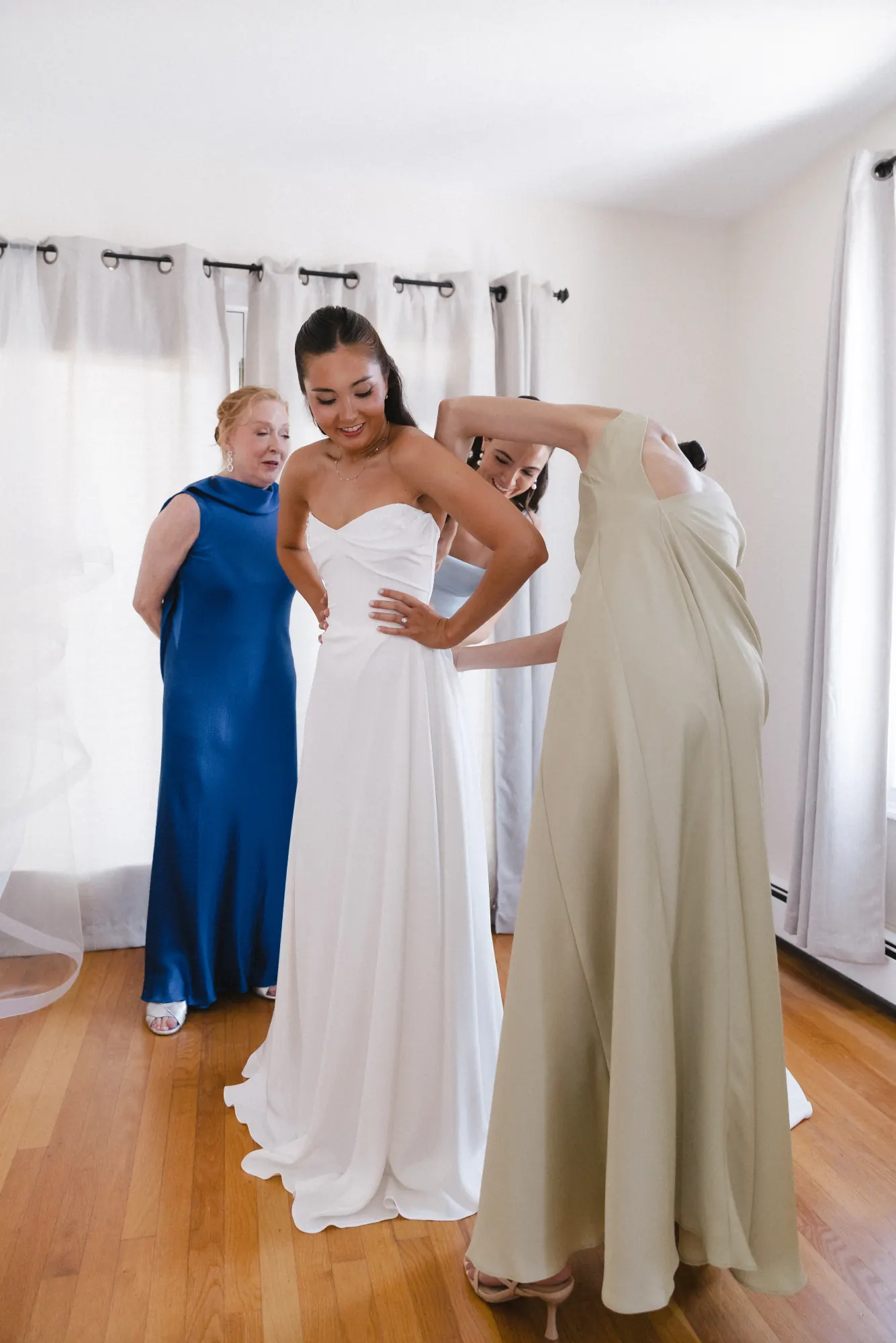 The bride's mother helps her into her gown at the Newport cottage