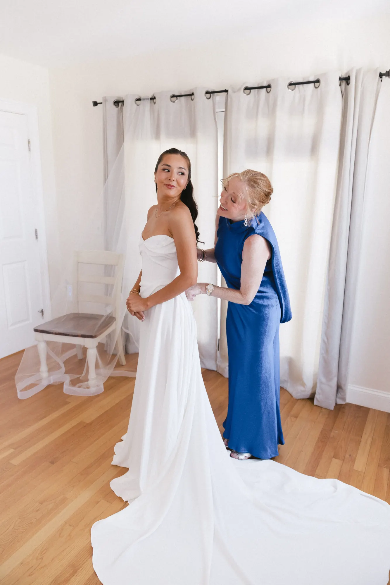 Bride and her mother with the gown's train spread across the floor