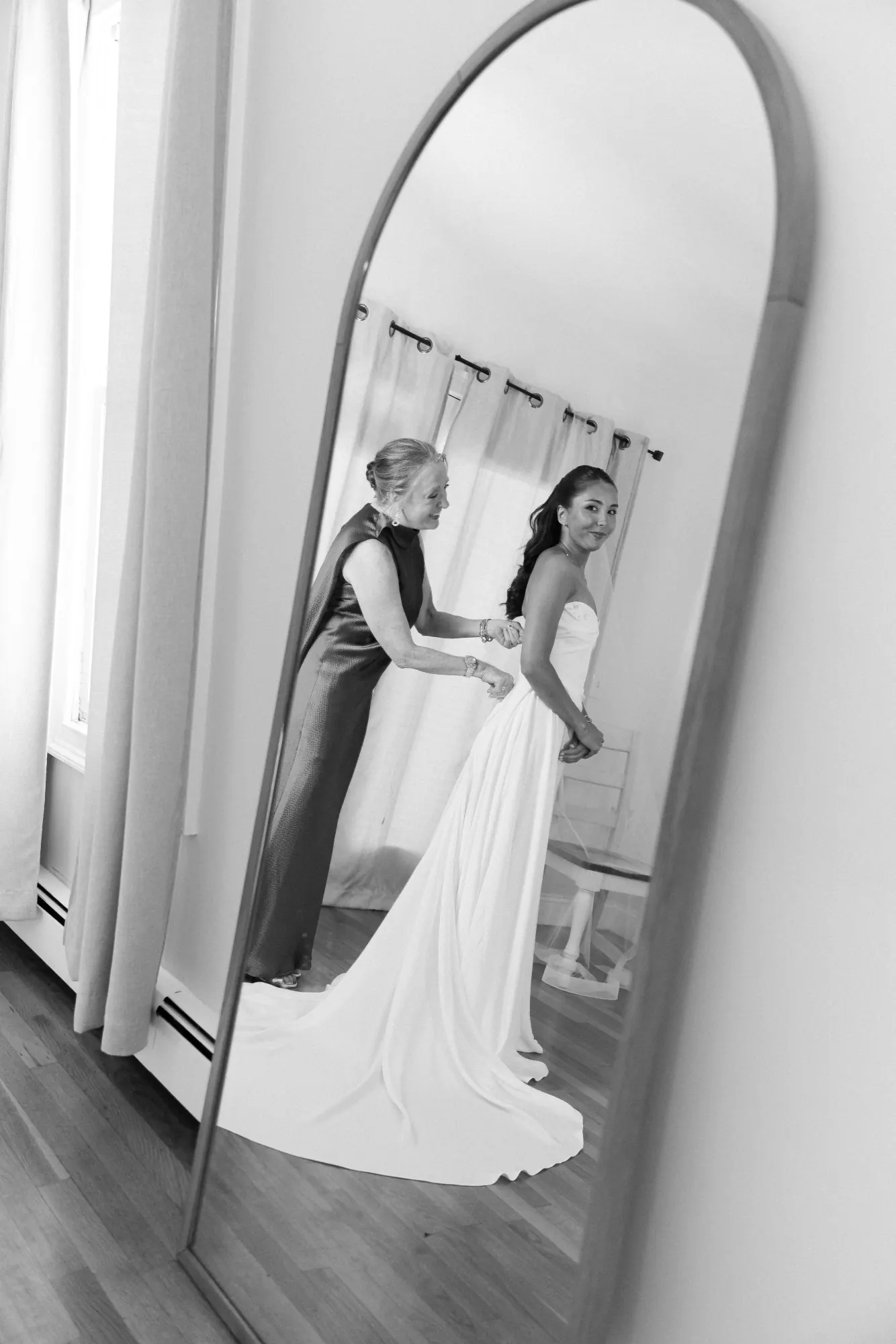 Black and white reflection of the bride and her mother in the mirror