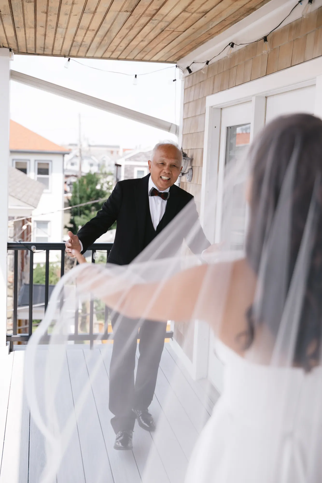 The bride's father takes in his first look as her veil catches the breeze