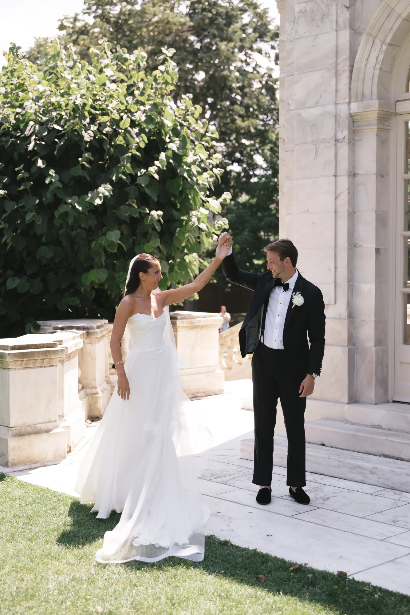 The groom twirls the bride on the marble terrace at The Elms
