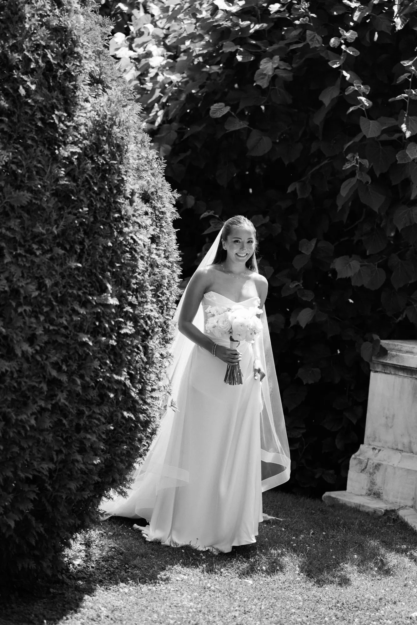 Black and white portrait of the bride beside the hedges at The Elms