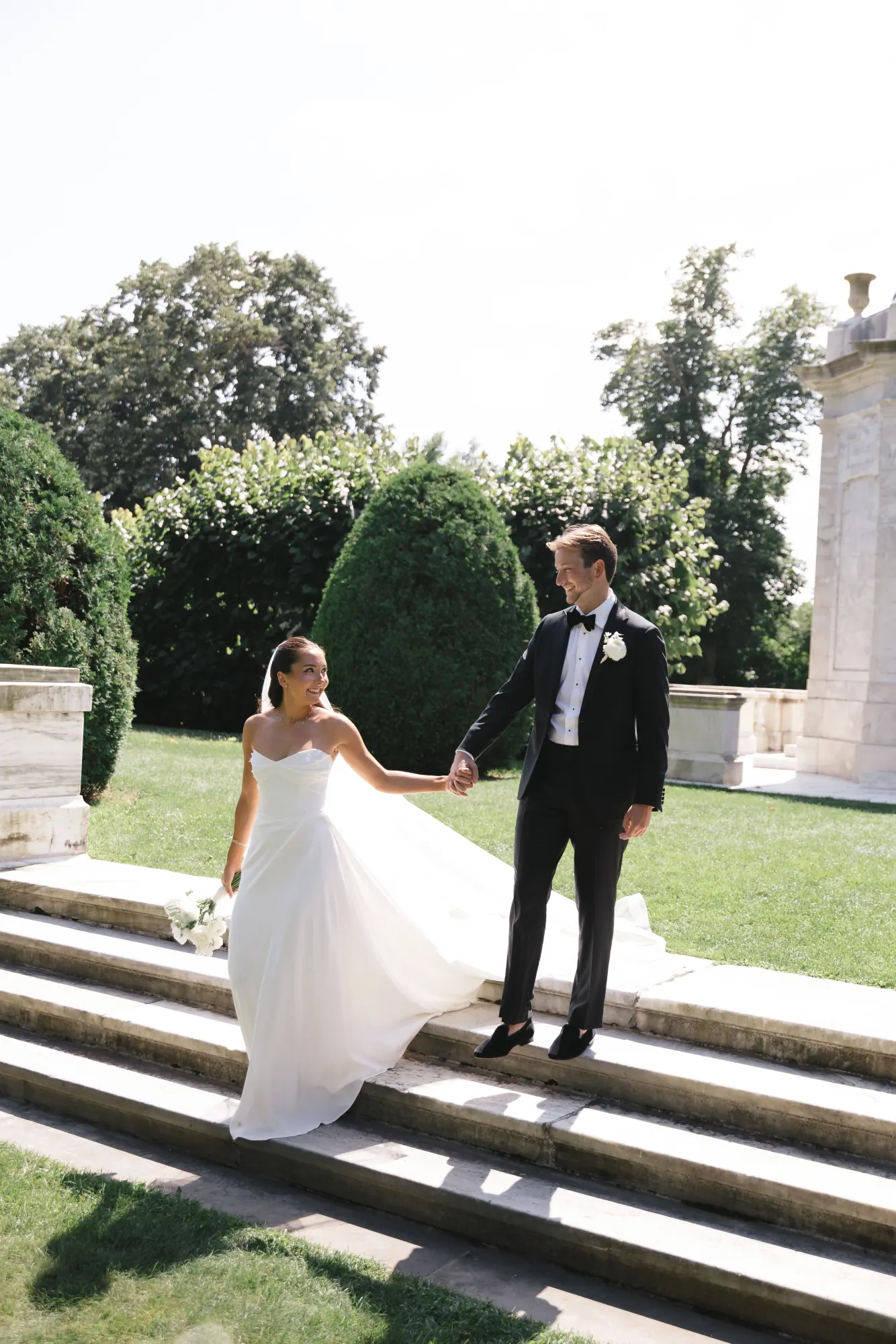 Couple descends the marble steps at The Elms hand in hand