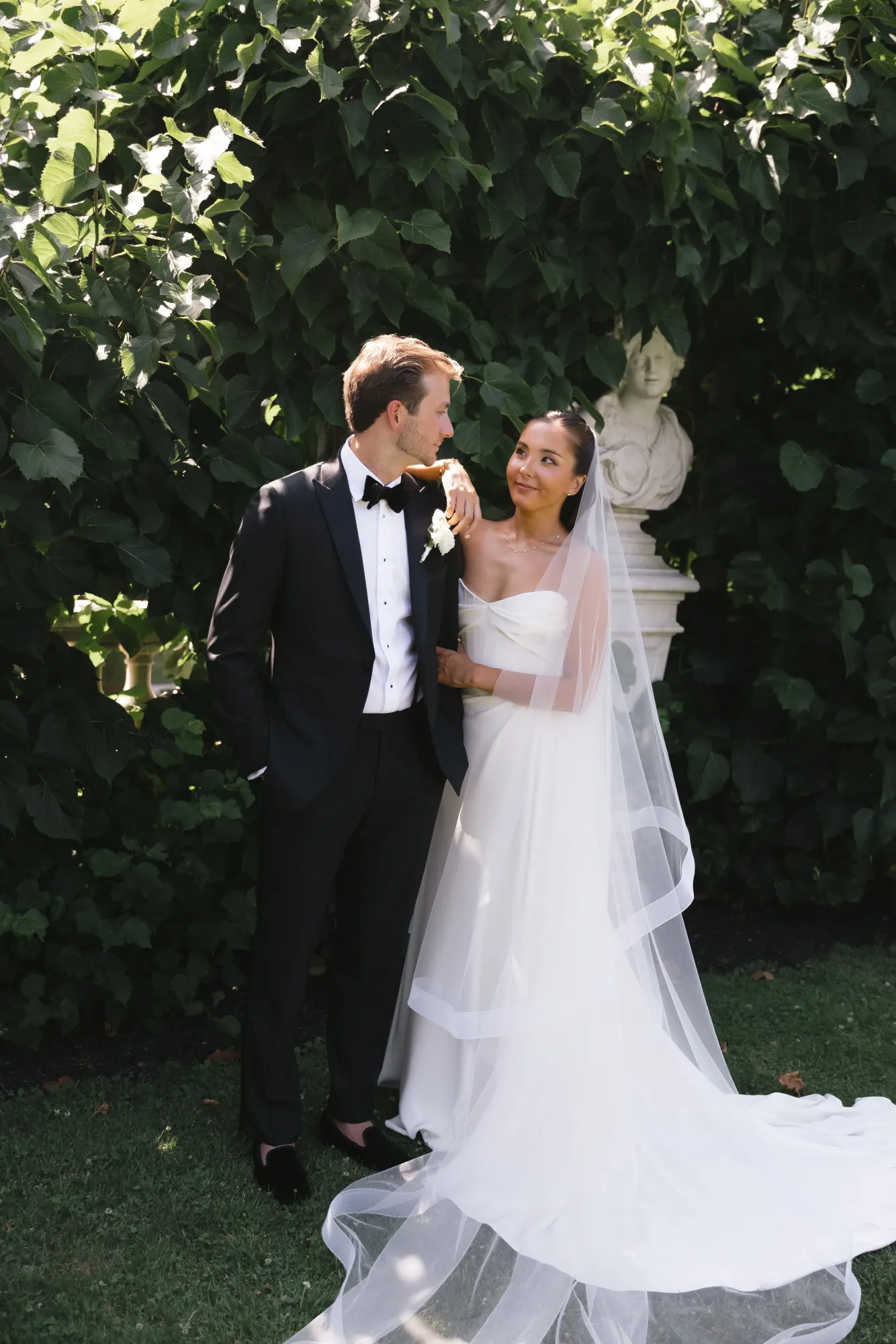 Bride and groom beneath the ivy arch in The Elms gardens