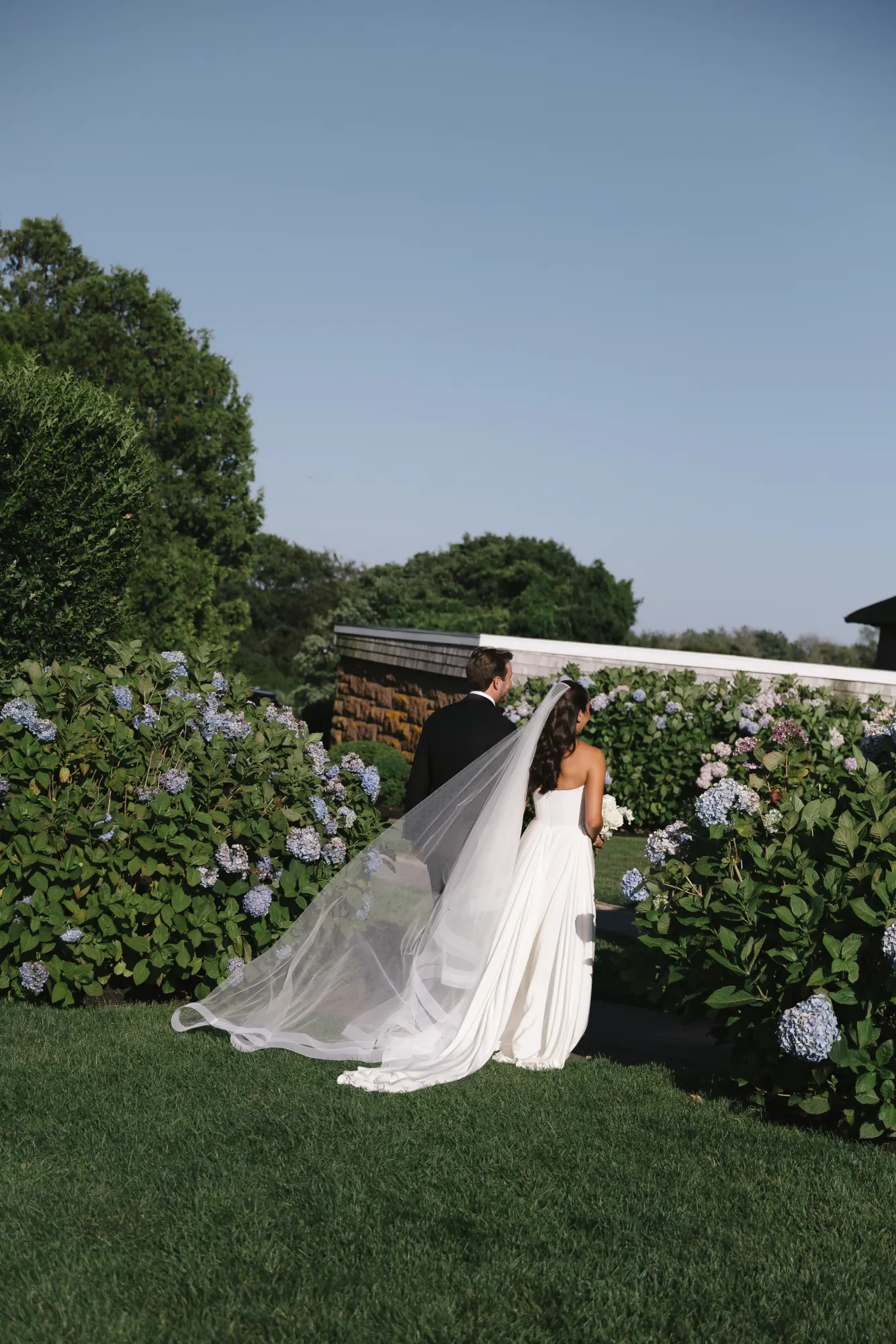 Newlyweds stroll past the hydrangeas at OceanCliff after the ceremony