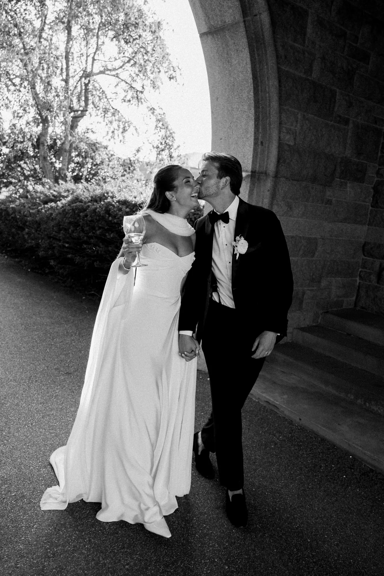 Black and white kiss beneath the stone archway at OceanCliff