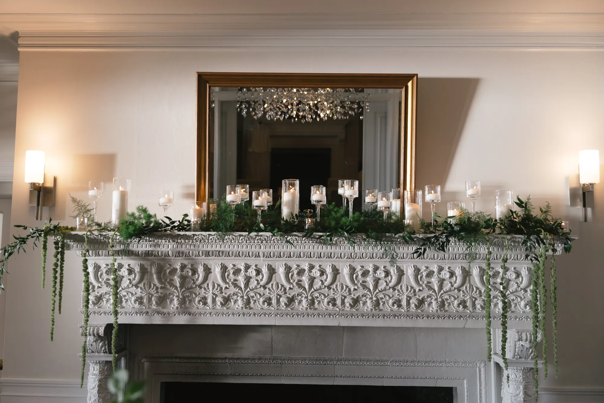 Greenery and candles dress the ballroom mantel at OceanCliff
