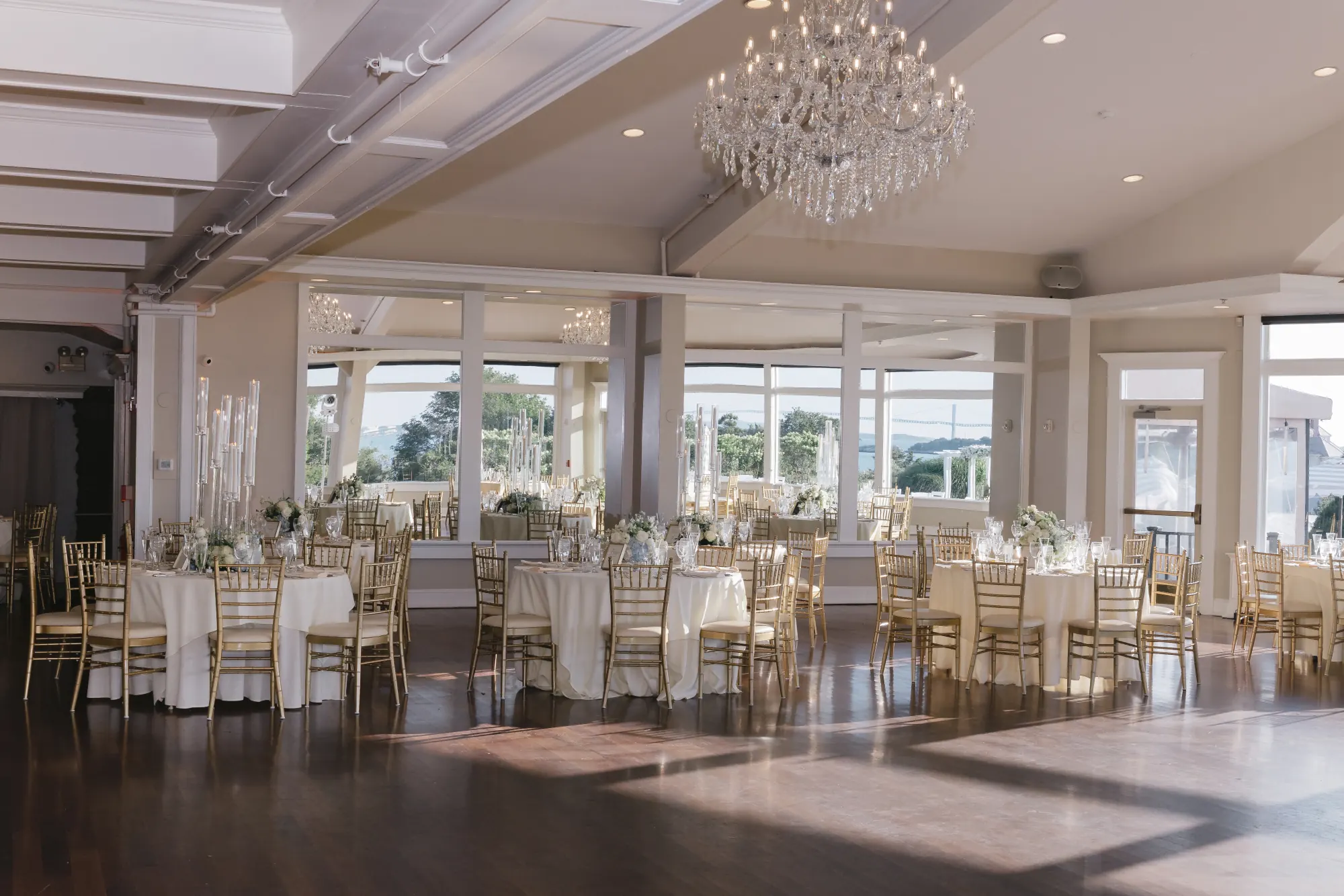 The OceanCliff ballroom set for dinner beneath crystal chandeliers