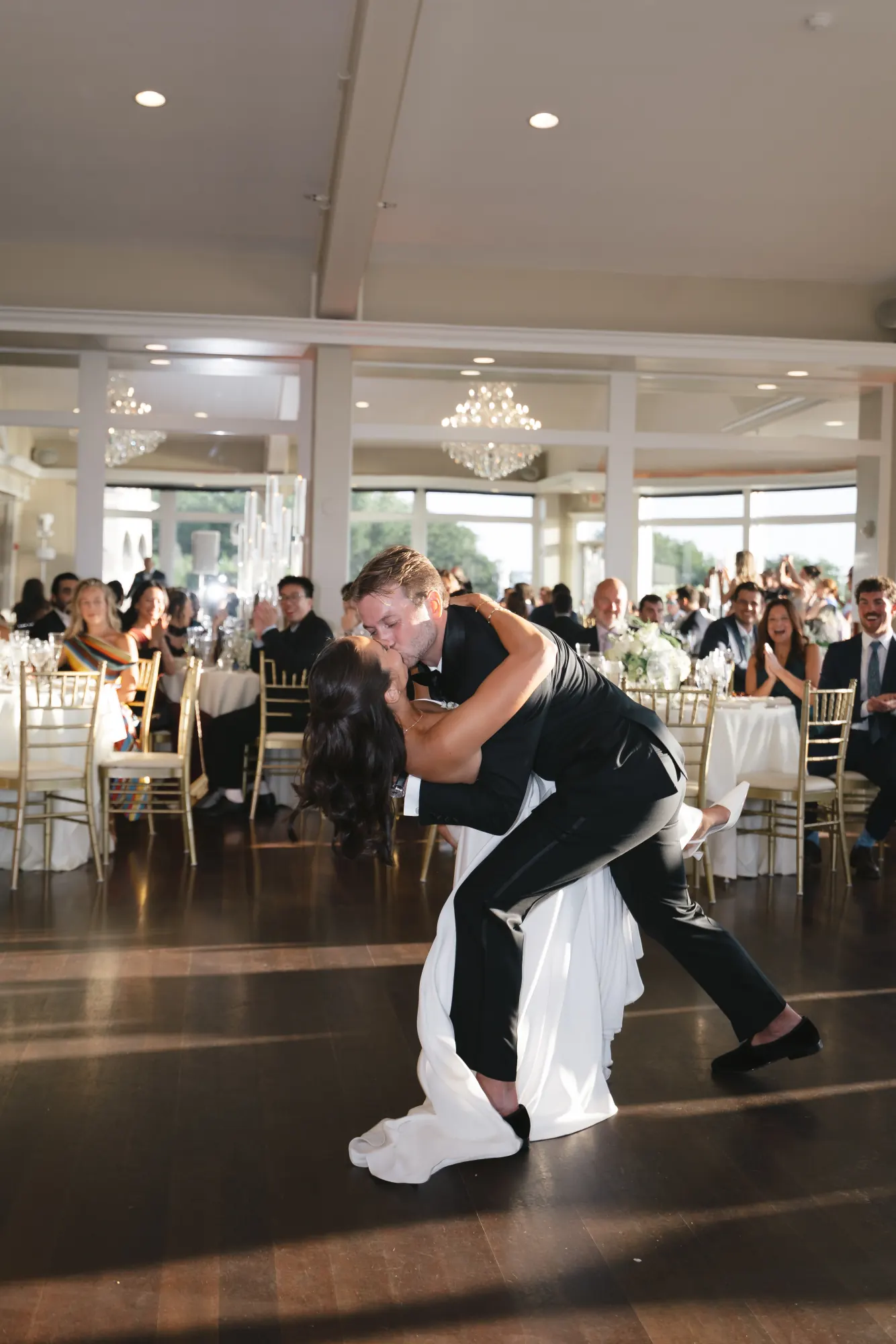 The groom dips the bride during their first dance