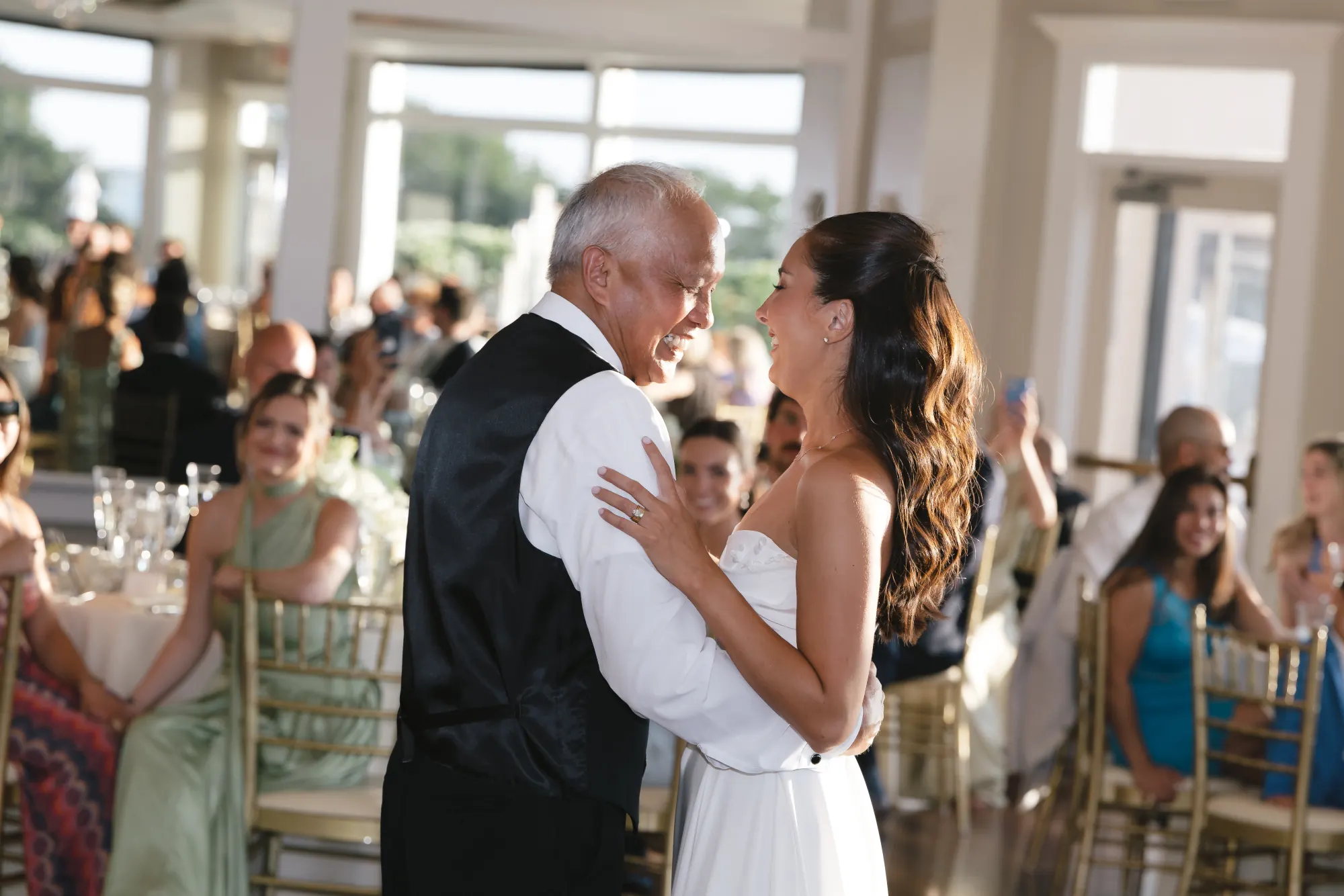 The bride dances with her father in the ballroom