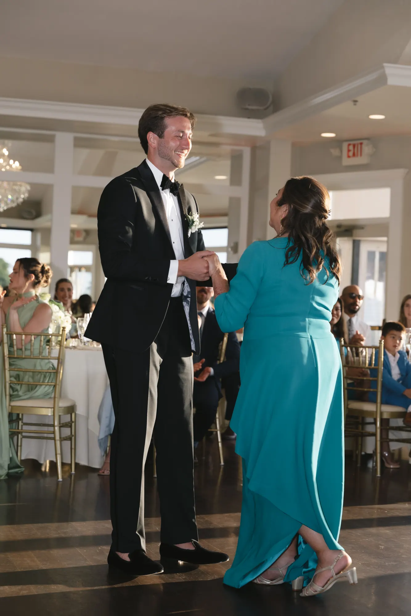 The groom takes his mother's hand for their dance