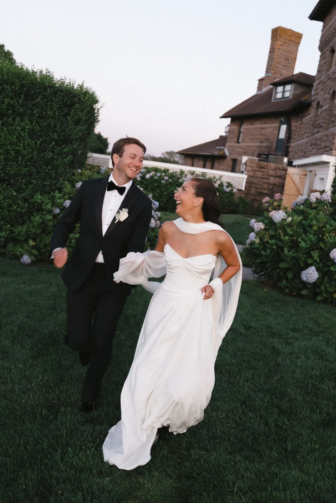 The couple stroll the lawn as the sun sets over Newport