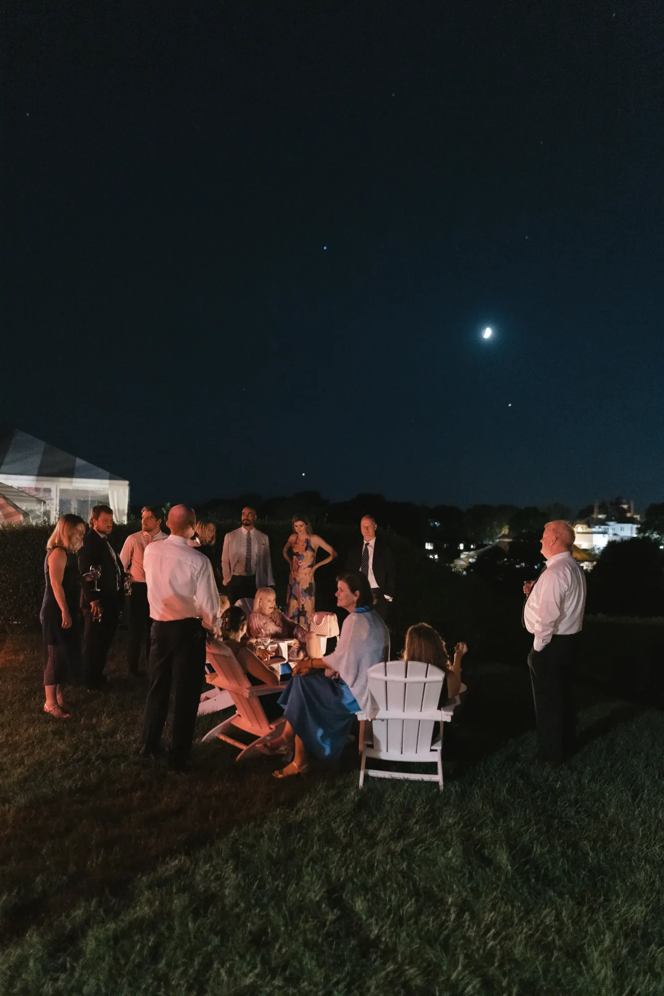 Guests take in the night air on the lawn under the moon