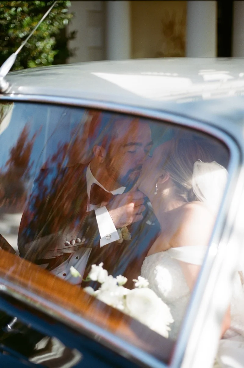 Couple kissing through vintage car