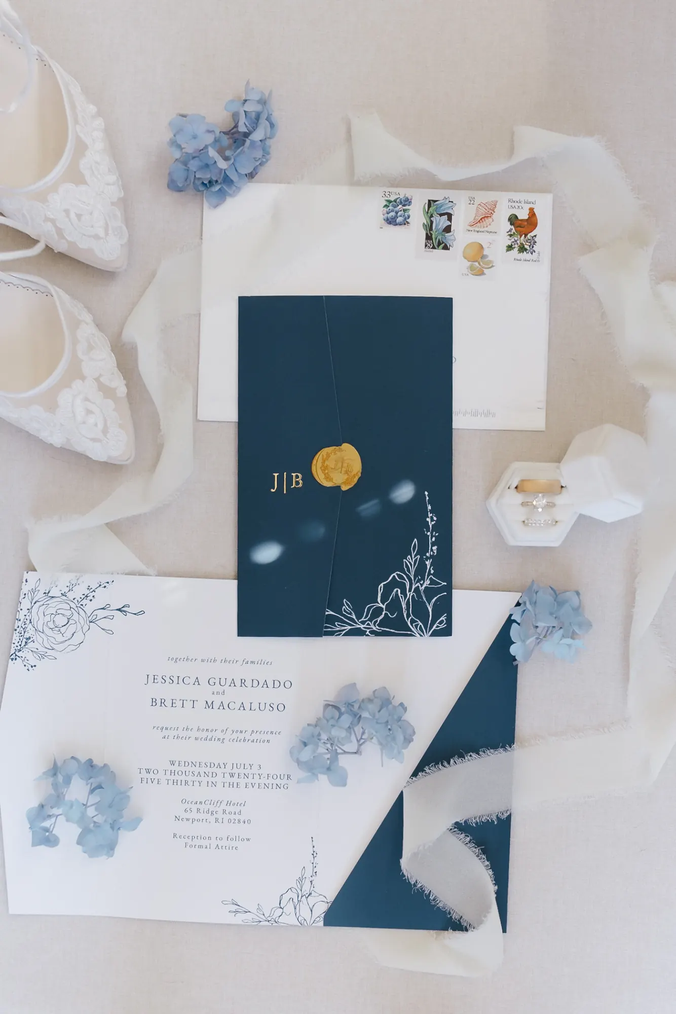 Navy and gold wedding invitation suite with a J and B wax seal, lace shoes and blue hydrangea for a Newport wedding