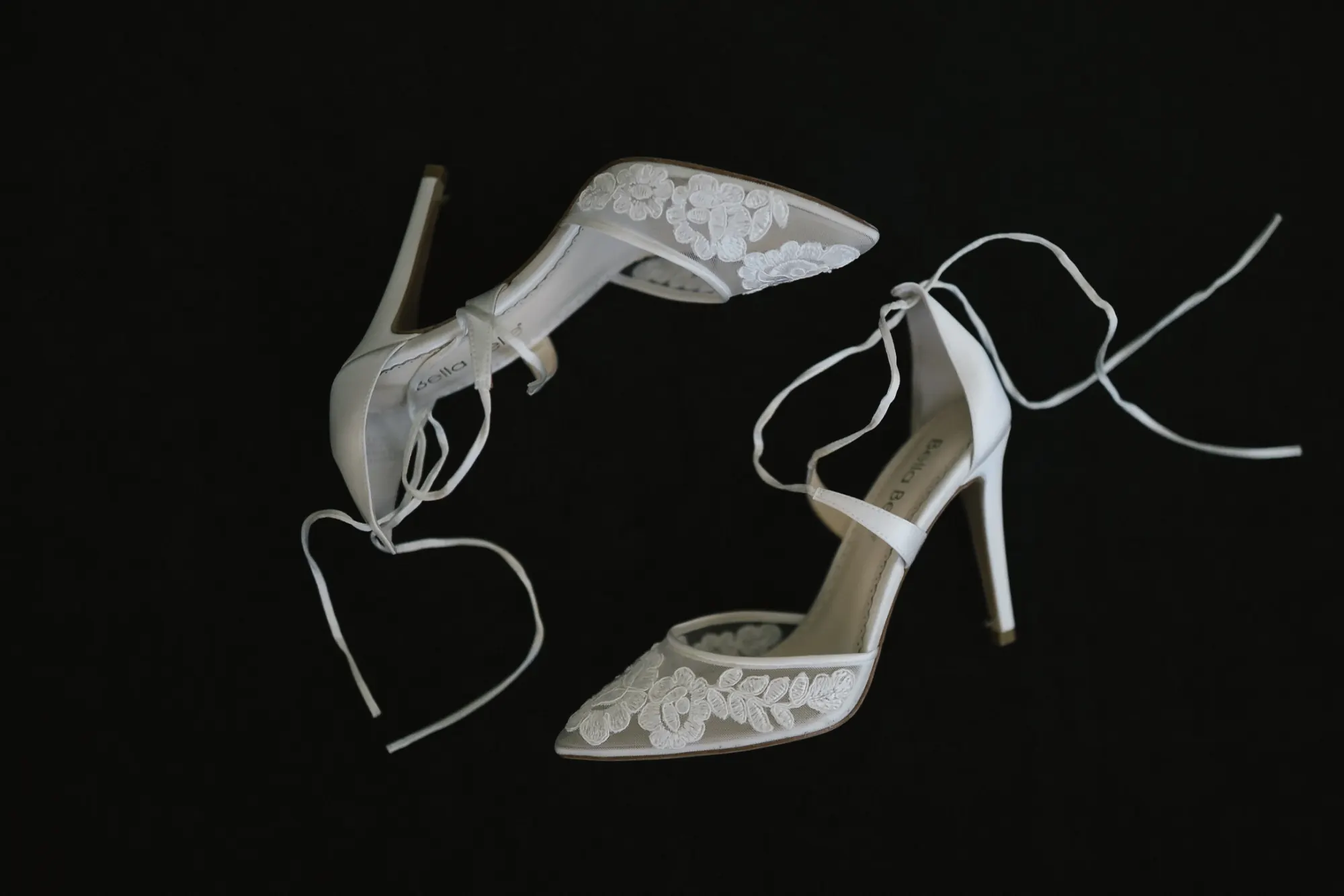 Bride's lace ankle-strap wedding heels styled on black
