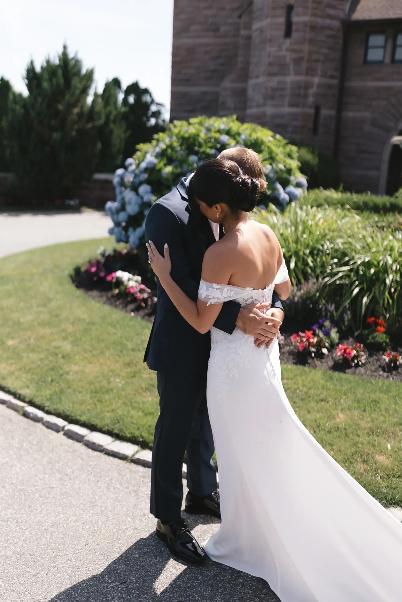 Bride and groom embrace during their first look in the OceanCliff garden