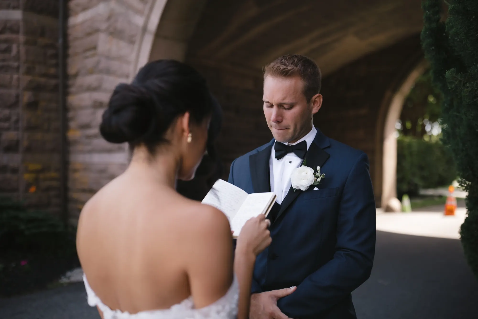 Groom reads his private vows to the bride beneath the OceanCliff stone archway
