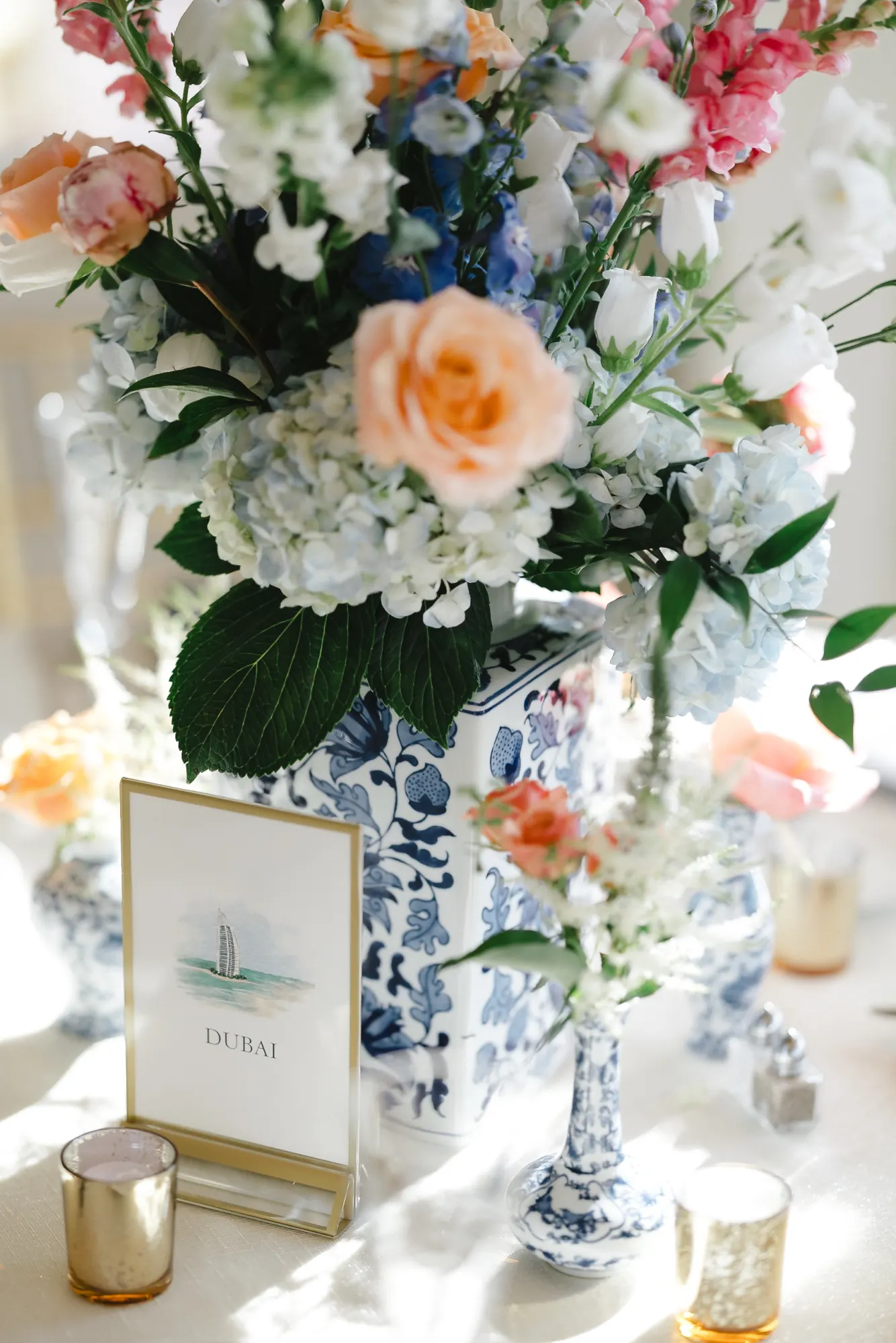 Reception centerpiece of peach roses and white hydrangea in a blue-and-white ginger jar at OceanCliff