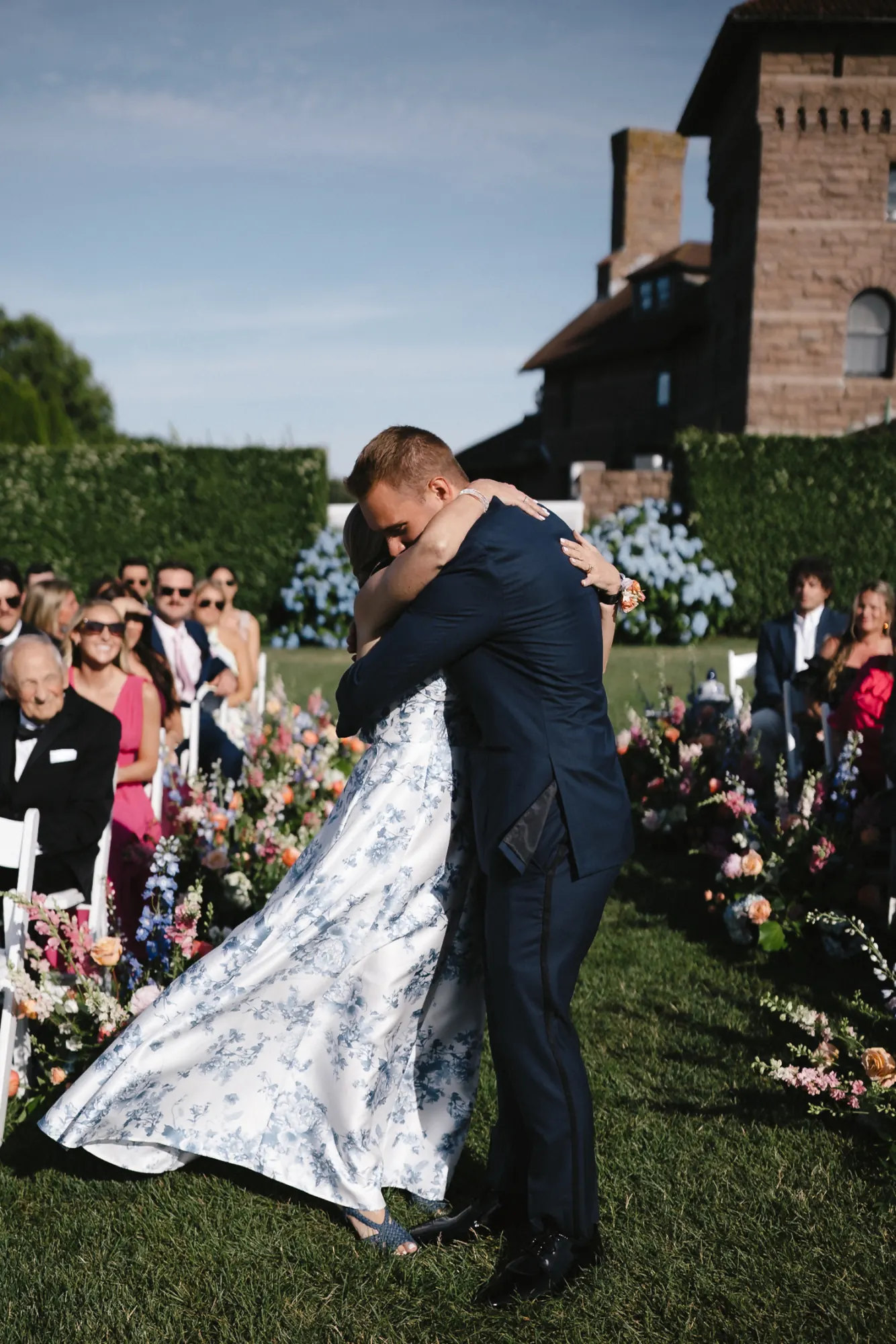 The groom embraces the bride's mother during the ceremony processional at OceanCliff, Newport