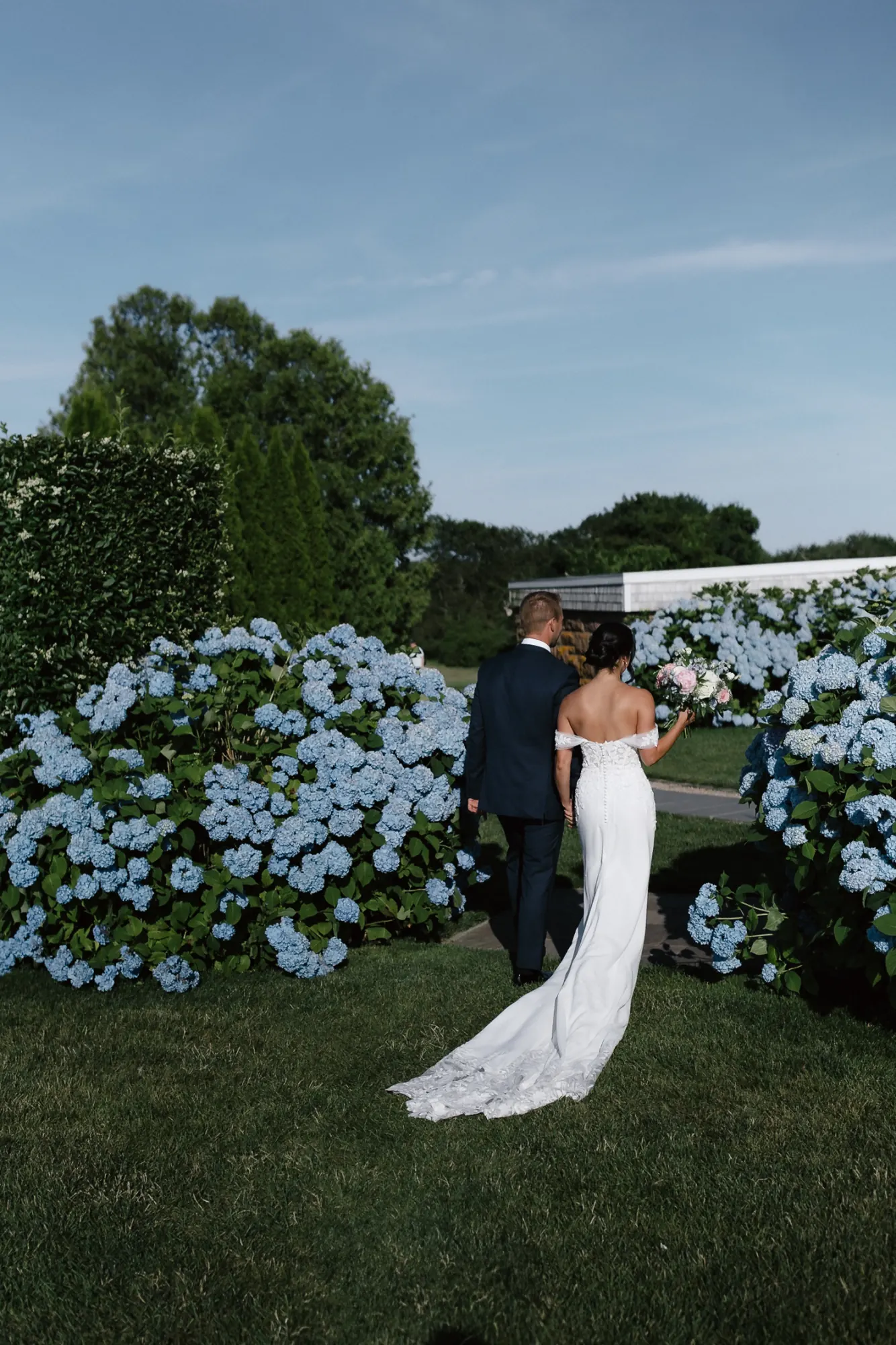 Bride and groom portrait among blue hydrangeas just after their Newport ceremony