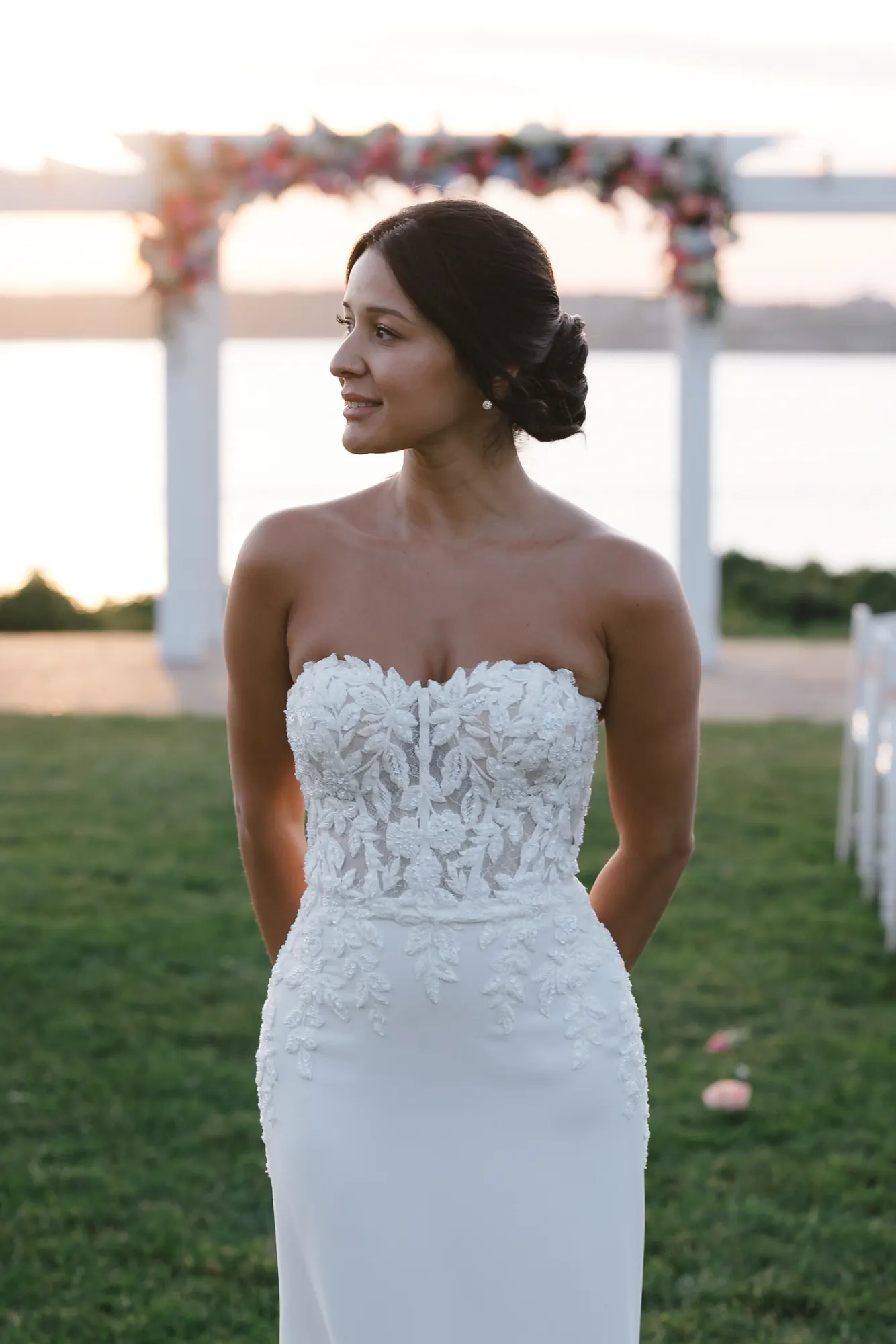 Bride in a strapless lace gown looks toward Narragansett Bay at OceanCliff in Newport, Rhode Island