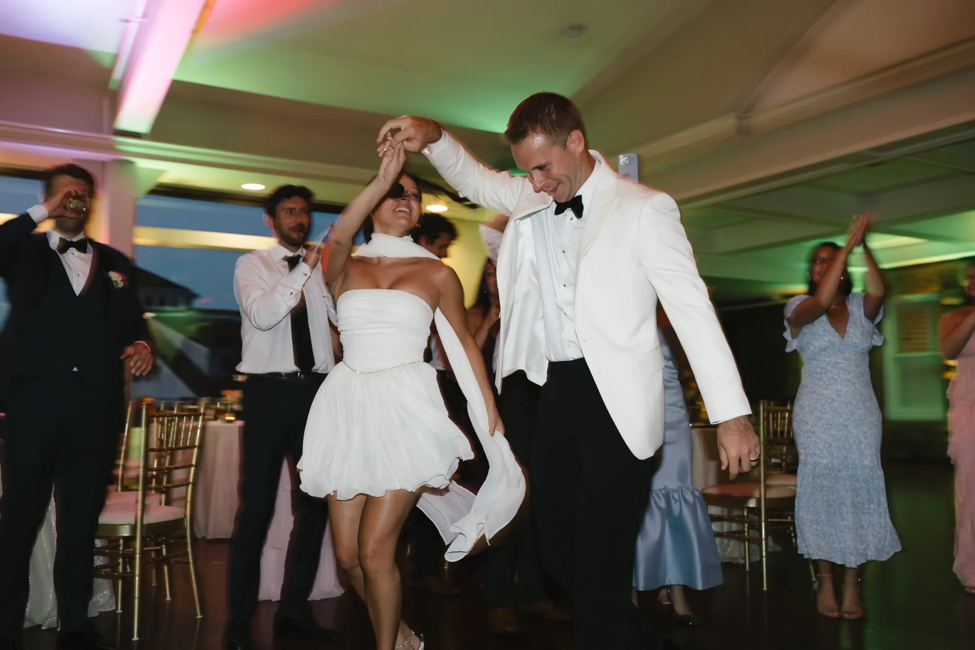 Grand entrance to the dance floor, the bride in a short white party dress at OceanCliff